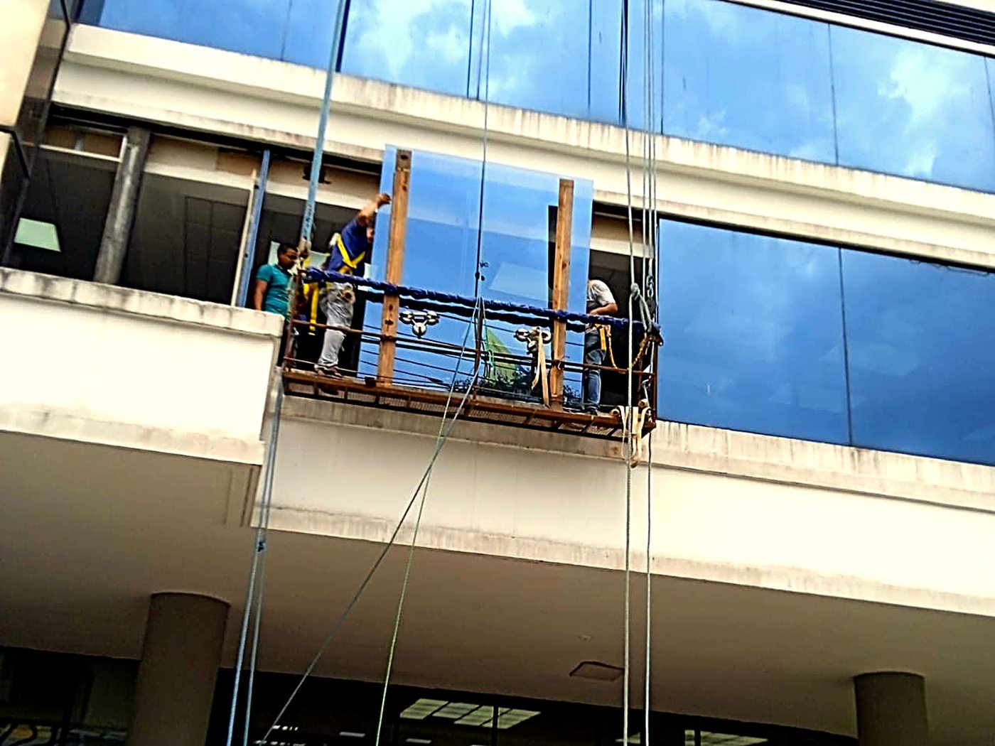 Izaje e instalación de panel de vidrio en edificio comercial